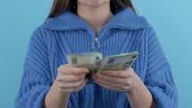 Woman counting cash money - EUR currency 100 euros banknotes on blue background. Jackpot, lottery prize, salary, profitable investment. High quality 4k footage