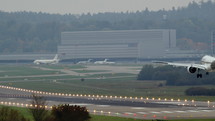 Airplane landing on a runway of a busy airport