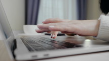 closeup of business woman typing on laptop. Female hands busy typing on keyboard. Freelancer girl working at home in winter