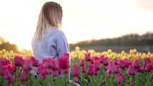 Blonde woman sitting alone in tulips field