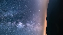 Vertical video of milky way galaxy and fast clouds motion in starry night sky over mountains and countryside Astronomy Time-lapse

