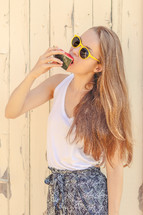 a teen girl eating a watermelon slice 