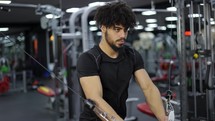 Guy exercising at gym for arm and shoulders muscles, slow motion.
