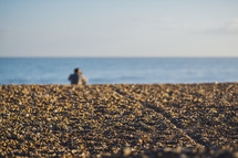 a man sitting on a beach 