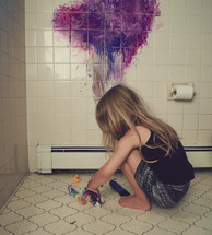 a child painting a bathroom tile wall 