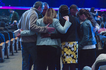 group praying in a circle in a church 