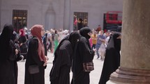 Group of young muslim teenagers girls in head scarf on a line to visit a museum
