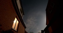 Night Time lapse of a bright moon shadows on a house wall, clouds moving in the sky, in Germany