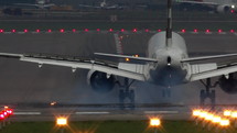 View from behind of a commercial airplane landing on a runway.
