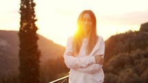 Portrait of a blonde woman enjoying mountains in lens flares.