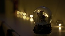 A Snow Globe in a Dimly Lit Room - Close Up