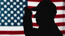 Silhouette American veteran stands at attention with military salute