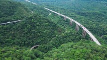 Aerial shoot reveal of a Highway in the forest - tunnel - showing cars, truck and traffic - Imigrantes Sao Paulo Brazil

