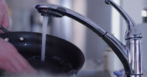 hand washes frying pan- slow motion