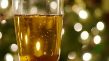 Champagne glass in front of a Christmas tree 