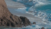 Waves crashing against rocks in slow motion