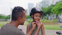 Dad, boy child with bike, helmet and safety with teaching, celebration or motivation for goal. Father, son and bicycle outdoor in street with learning, helping hand and support
