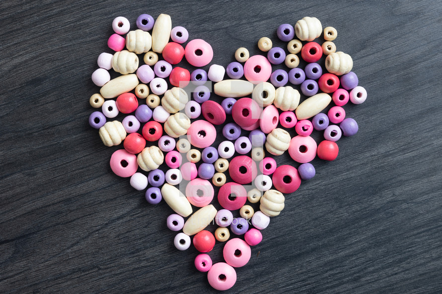 pink and purple beads in the shape of a heart 