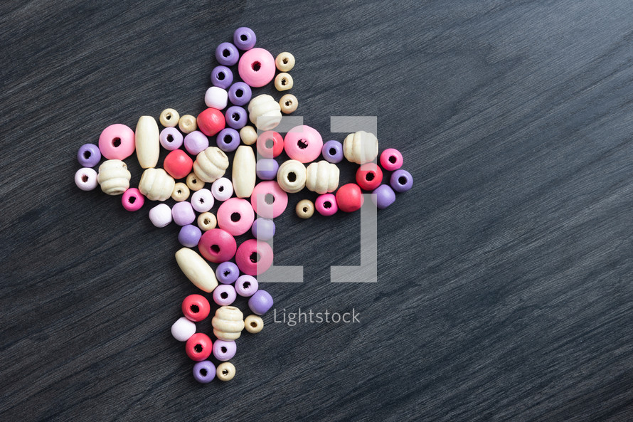 pink and purple beads in the shape of a cross