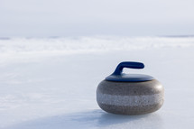 One blue curling rock on a frozen lake
