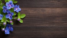 Beautiful blue flowers on wooden background. Top view with copy space