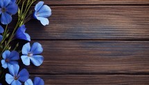 Blue flowers on brown wooden background. Top view with copy space.