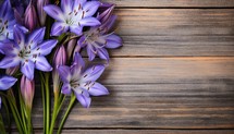 Bouquet of purple flowers on a wooden background. View from above.