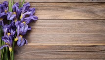 Bouquet of purple irises on wooden background. Top view with copy space