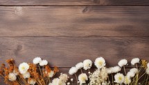 Dried flowers on brown wooden background. Top view with copy space