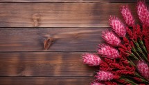 Red flowers on a wooden background. Top view. Copy space.