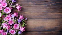 Bouquet of pink and purple flowers on a wooden background.