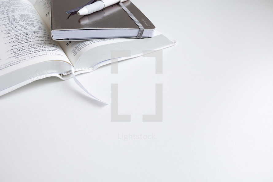 Bible and notebook on white background