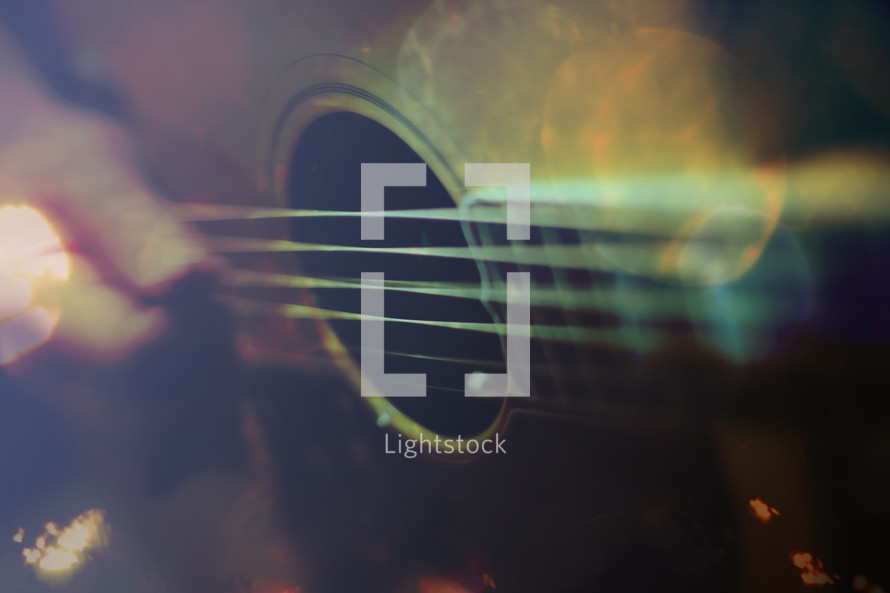 a blurred motion picture of guitar playing with digitally added bokeh and color layers