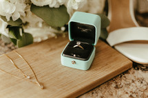 Wedding ring flatlay with wedding jewelry, wedding flowers, and wedding shoes