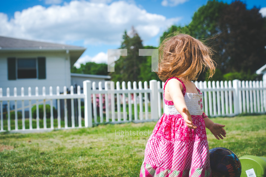a little girl playing in her backyard 