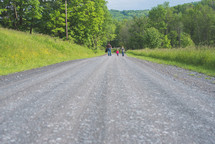 a father and his kids walking down a rural road 