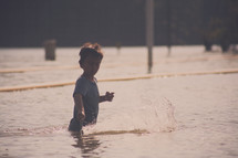 boy child splashing in a lake 