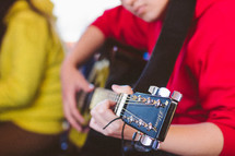 teen boy playing a guitar 