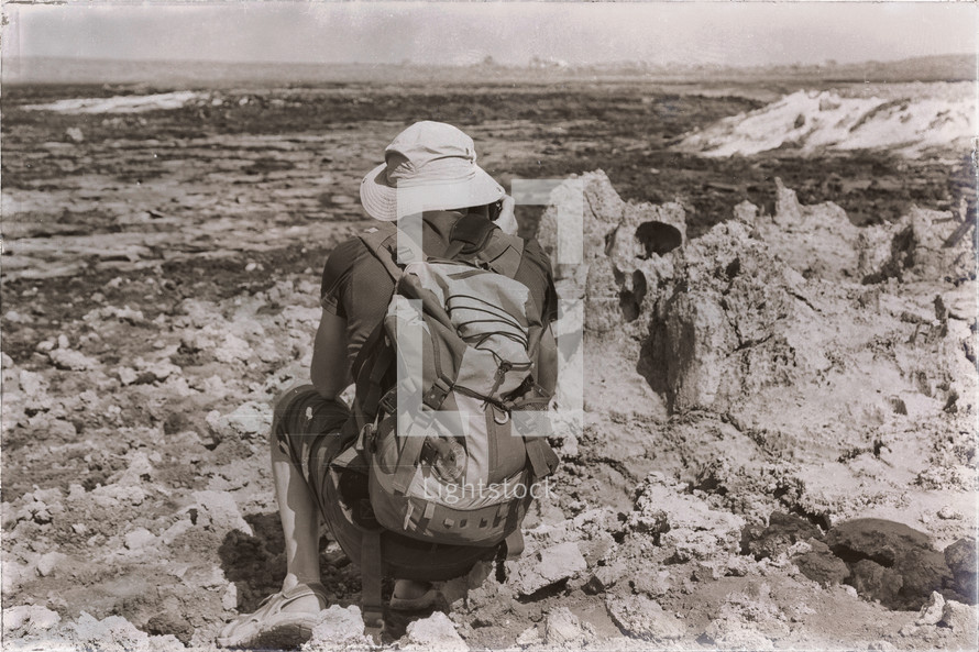 a man with a backpack viewing a volcanic depression 