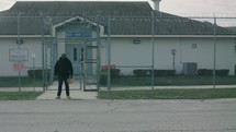 guy standing outside of a prison 