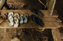 muddy sandals and flip flops on a step in Yau Yau village 