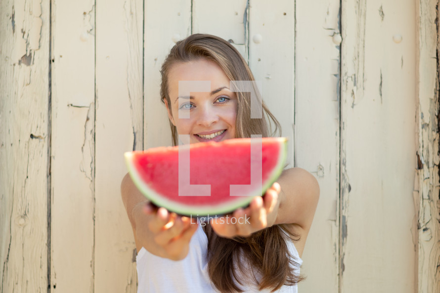 a woman holding a watermelon 