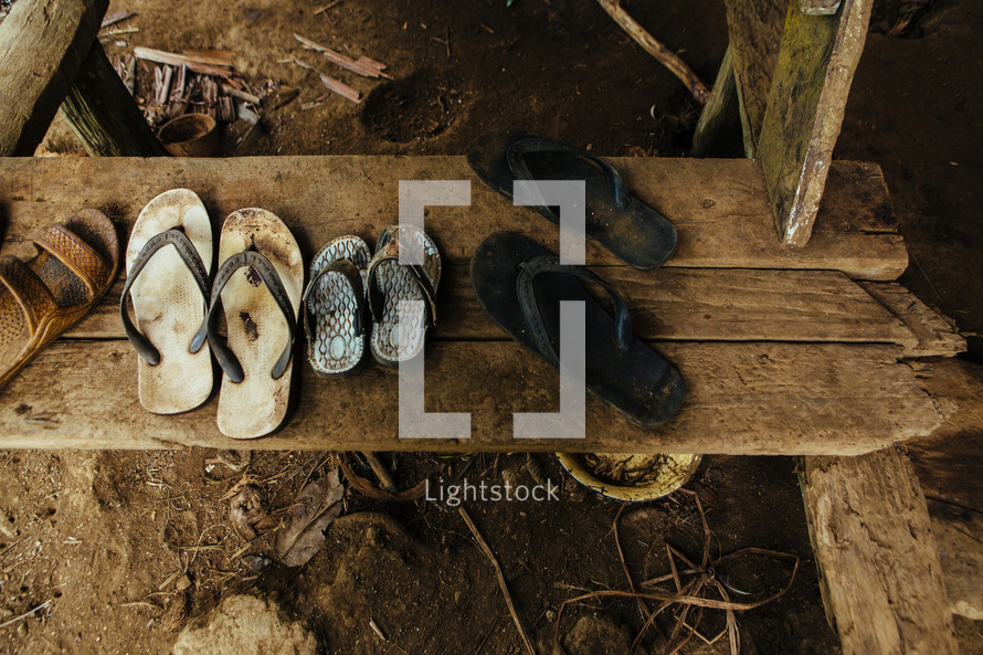 muddy sandals and flip flops on a step in Yau Yau village 