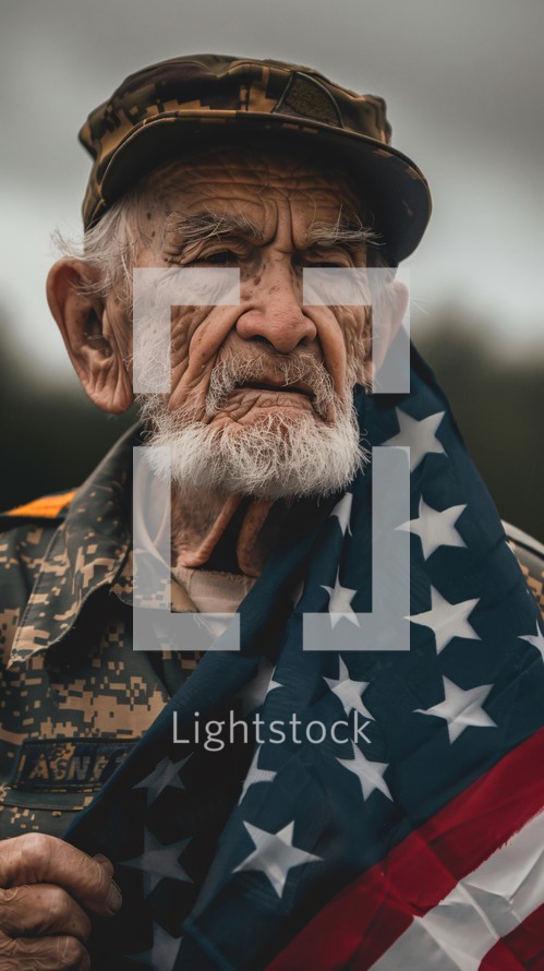 Somber senior man in fatigues with a flag