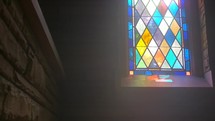 sunlight through a stained glass window in an old chapel 