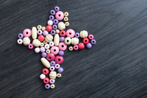 pink and purple beads in the shape of a cross