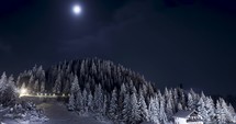 Timelapse of Snowy Mountain Landscape With Bright Full Moon On A Winter Night.