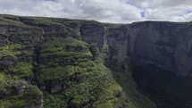 Drone flies from canyon toward Fumaça waterfall in Chapada Diamantina