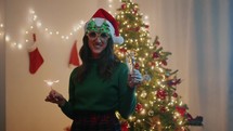Girl Celebrate and dance with sparkles against Christmas tree for new year