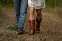Man and woman's legs, as they are walking across a field